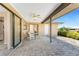 This covered patio offers a relaxing outdoor space with stone pavers and views of the manicured backyard at 39 Bunker Pl, Rotonda West, FL 33947