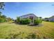 Spacious backyard with lush lawn, mature hedges, and a screened-in patio area at 4004 Landor Ct, Venice, FL 34293
