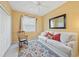 Bright bedroom with seating area featuring a white sofa, rocking chair, and area rug at 4004 Landor Ct, Venice, FL 34293