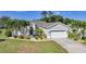 Charming single-story home with a well-manicured lawn, palm trees, and a two-car garage at 4004 Landor Ct, Venice, FL 34293
