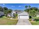Attractive home featuring a manicured lawn, palm trees, and a spacious driveway leading to a garage at 4004 Landor Ct, Venice, FL 34293
