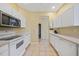 Functional kitchen with white cabinets, updated appliances, and tile flooring at 4004 Landor Ct, Venice, FL 34293