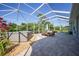 Spacious screened-in lanai offering a hot tub, dining area, and serene backyard views at 4004 Landor Ct, Venice, FL 34293