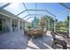 Expansive lanai showcasing a dining table, seating, and lovely views of the backyard at 4004 Landor Ct, Venice, FL 34293