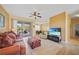 Well-lit living room featuring a comfortable sofa, ceiling fan, and access to a patio for outdoor enjoyment at 4004 Landor Ct, Venice, FL 34293