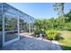 Relaxing screened patio area with brick pavers, lush landscaping, and outdoor furniture at 4004 Landor Ct, Venice, FL 34293