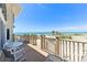 Beautiful beachfront balcony with a dining table and chairs overlooking the white sand beach and clear blue ocean at 5000 Gasparilla Rd # 23A, Boca Grande, FL 33921