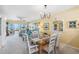 Elegant dining area with ocean views, featuring a glass table, chandelier, and seamless living space at 5000 Gasparilla Rd # 23A, Boca Grande, FL 33921