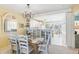 Inviting dining area with a glass-top table, chandelier, and open view of the adjacent kitchen at 5000 Gasparilla Rd # 23A, Boca Grande, FL 33921