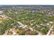 Expansive aerial view showcasing a lush, green neighborhood with mature trees and a small lake nearby at 521 Artists Ave, Englewood, FL 34223