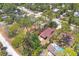 Aerial view of a home, surrounded by mature trees, showcasing its backyard and neighboring houses at 521 Artists Ave, Englewood, FL 34223