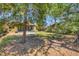 Wide backyard with stone border, patio seating, and ample green space, shaded by large trees at 521 Artists Ave, Englewood, FL 34223