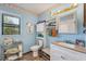 A view of the bathroom featuring a single sink vanity, white cabinets and shelves and a window at 521 Artists Ave, Englewood, FL 34223