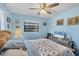 A view of the bedroom featuring blue walls, a ceiling fan, carpet floors, and one window at 521 Artists Ave, Englewood, FL 34223