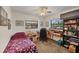 Cozy bedroom with a desk, chair, bookshelves, and natural light streaming through the windows at 521 Artists Ave, Englewood, FL 34223