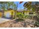 Eye-level view of a charming home featuring a lovely yellow exterior with an attached garage at 521 Artists Ave, Englewood, FL 34223