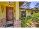 Charming front door with decorative brick accents and a welcoming entryway with lush landscaping at 521 Artists Ave, Englewood, FL 34223