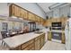 A view of the kitchen with skylight, wood cabinets, white countertop and dining set in background at 521 Artists Ave, Englewood, FL 34223