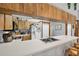 A view of the kitchen featuring wood cabinets, white countertops, and a stainless-steel sink at 521 Artists Ave, Englewood, FL 34223