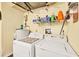 Functional laundry area with a washer, dryer, water heater and shelving at 521 Artists Ave, Englewood, FL 34223