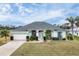 Inviting single-story home featuring lush landscaping, a two-car garage, and a well-manicured lawn at 642 Boundary Blvd, Rotonda West, FL 33947