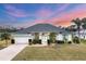 Inviting single-story home featuring lush landscaping, a two-car garage, and a well-manicured lawn at 642 Boundary Blvd, Rotonda West, FL 33947
