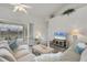 Bright living room features wood floors, comfortable seating, and sliding glass doors to the outdoor pool area at 642 Boundary Blvd, Rotonda West, FL 33947