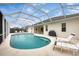 Back of house with a screened in pool, lounge furniture, and grill at 642 Boundary Blvd, Rotonda West, FL 33947