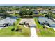 Aerial view of home on a canal with lush landscaping and a screened in pool at 68 Long Meadow Ln, Rotonda West, FL 33947