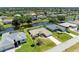 Aerial view of home with waterfront views, green lawn, mature trees, and screened pool at 68 Long Meadow Ln, Rotonda West, FL 33947
