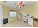 Cozy bedroom featuring a ceiling fan, window, and desk area at 68 Long Meadow Ln, Rotonda West, FL 33947