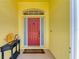 Cheerful front entrance with a red door, yellow walls and cute decorations at 68 Long Meadow Ln, Rotonda West, FL 33947