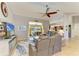 Open living room with ceiling fan, tile floors, and sliding glass doors to the pool area at 68 Long Meadow Ln, Rotonda West, FL 33947