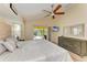 A comfortable main bedroom with a view of the pool area and a ceiling fan at 68 Long Meadow Ln, Rotonda West, FL 33947