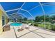 Inviting screened pool area with patio furniture, perfect for relaxation and enjoying the serene water view at 68 Long Meadow Ln, Rotonda West, FL 33947