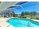 Refreshing pool with screened enclosure surrounded by lush landscaping and serene views at 68 Long Meadow Ln, Rotonda West, FL 33947