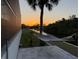 Scenic backyard with a hammock, swaying palm trees, and serene water views at sunset at 725 Clearview Dr, Port Charlotte, FL 33953