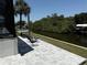 Backyard with a patio, outdoor seating, swaying palm trees, and peaceful water views at 725 Clearview Dr, Port Charlotte, FL 33953