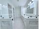 Bright bathroom with white double vanity, modern lighted mirrors, stylish tile floor, and glass shower at 725 Clearview Dr, Port Charlotte, FL 33953