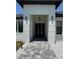Inviting front entrance with a paved walkway and contemporary black double doors at 725 Clearview Dr, Port Charlotte, FL 33953