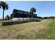 Back of home featuring screened in porch with outdoor furniture, landscaping, and privacy wall at 725 Clearview Dr, Port Charlotte, FL 33953