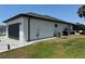 Exterior view of home showcasing the dark garage door, modern architectural elements, and landscaping at 725 Clearview Dr, Port Charlotte, FL 33953