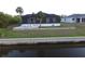 Back of home featuring screened in porch with outdoor furniture, landscaping, and privacy wall at 725 Clearview Dr, Port Charlotte, FL 33953
