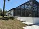 Screened-in lanai exterior showing steps, landscaping, and a peek into the outdoor living space at 725 Clearview Dr, Port Charlotte, FL 33953