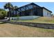 Home exterior showcasing a screened lanai, landscaping, and waterfront views, great for entertaining at 725 Clearview Dr, Port Charlotte, FL 33953