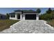 Charming single-story home featuring a paved driveway, two-car garage, and well-maintained landscaping at 725 Clearview Dr, Port Charlotte, FL 33953