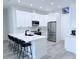 Modern kitchen features white cabinets, stainless appliances, island with seating, and sleek black fixtures at 725 Clearview Dr, Port Charlotte, FL 33953