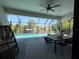 Enclosed patio featuring dining area, comfortable furniture, and a view of the pool at 725 Clearview Dr, Port Charlotte, FL 33953