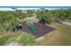 Aerial view of a neighborhood playground, surrounded by tropical trees, condos and lawns at 7470 Palm Island Dr # 2813, Placida, FL 33946