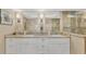 Bathroom featuring double vanity, decorative mirrors, and tiled shower at 7470 Palm Island Dr # 2813, Placida, FL 33946